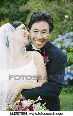 Picture - Asian newlyweds hugging. Fotosearch