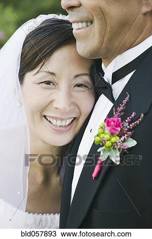 Stock Image - Asian newlyweds hugging. Fotosearch