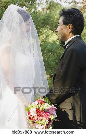 Stock Photo - Asian newlyweds smiling at each other. Fotosearch
