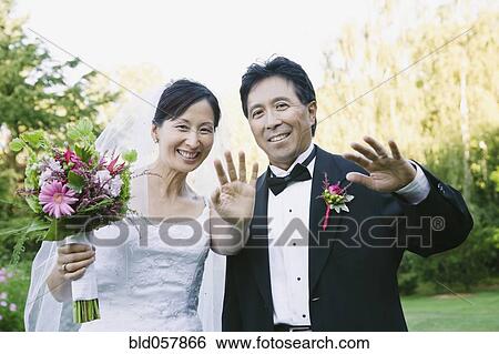 Stock Photograph - Asian newlyweds waving. Fotosearch