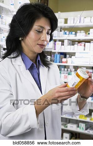 Asian pharmacist reading medication View Large Photo Image Stock Photograph - Asian pharmacist reading medication. Fotosearch