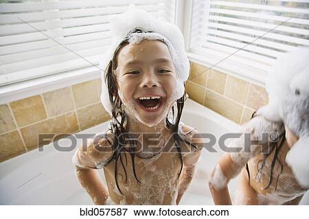 Stock Photo - Asian sisters in bubble bath. Fotosearch