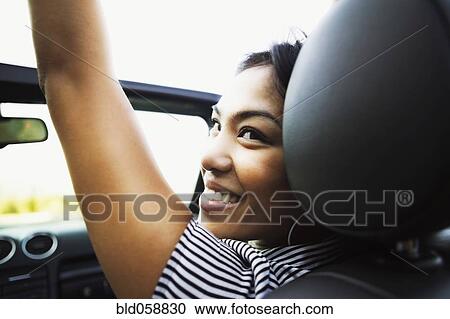 Stock Image - Asian woman in convertible car. Fotosearch
