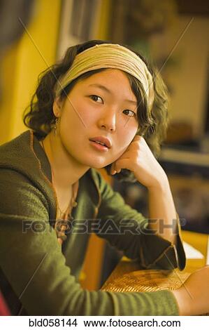 Picture - Asian woman leaning on table. Fotosearch