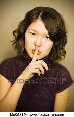Stock Photograph - Asian woman shushing. Fotosearch