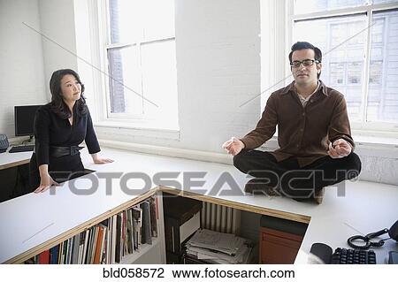 Hispanic businessman meditating next to coworker View Large Photo Image Stock Image - Hispanic businessman meditating next to coworker. Fotosearch