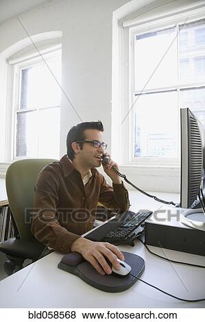 Stock Photo - Hispanic businessman talking on telephone. Fotosearch