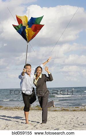 Hispanic businesspeople holding broken beach umbrella View Large Photo Image Stock Photography - Hispanic businesspeople holding broken beach umbrella. Fotosearch
