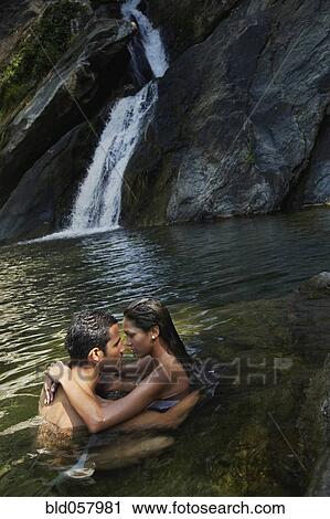 Stock Image - Hispanic couple hugging in water. Fotosearch