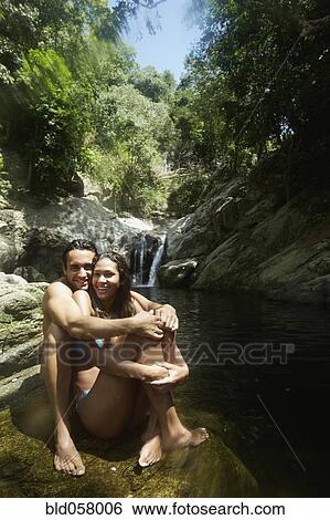 Stock Photograph - Hispanic couple hugging in water. Fotosearch