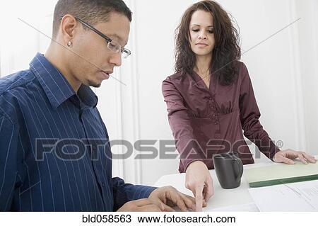Stock Image - Hispanic couple looking at paperwork. Fotosearch
