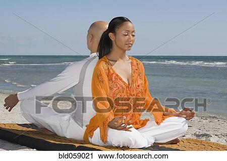 Stock Image - Hispanic couple meditating. Fotosearch