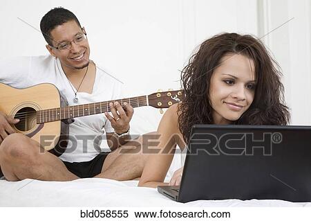Hispanic couple relaxing on bed View Large Photo Image Stock Photography - Hispanic couple relaxing on bed. Fotosearch