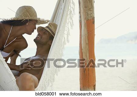 Stock Image - Hispanic couple smiling at each other. Fotosearch