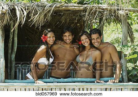 Hispanic couples in beach hut View Large Photo Image Stock Photo - Hispanic couples in beach hut. Fotosearch