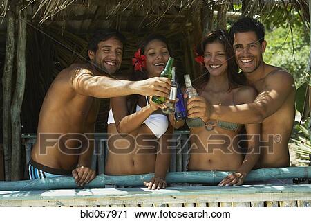 Hispanic couples toasting in beach hut View Large Photo Image Stock Image - Hispanic couples toasting in beach hut. Fotosearch