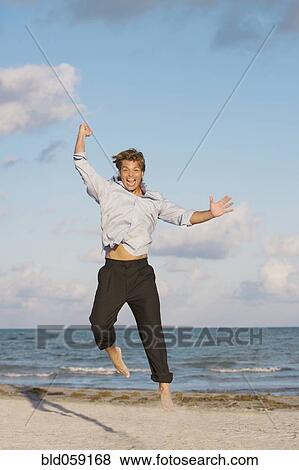 Hispanic man jumping on beach View Large Photo Image Stock Photo - Hispanic man jumping on beach. Fotosearch