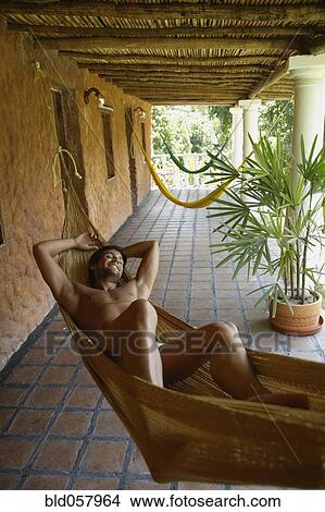 Picture - Hispanic man laying in hammock. Fotosearch