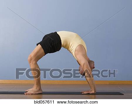 Stock Image - Hispanic man practicing yoga. Fotosearch
