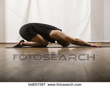Stock Photo - Hispanic man practicing yoga. Fotosearch