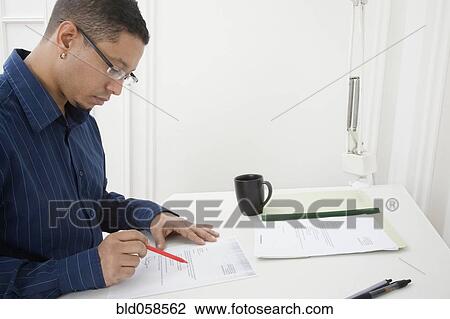 Hispanic man reading paperwork View Large Photo Image Stock Image - Hispanic man reading paperwork. Fotosearch