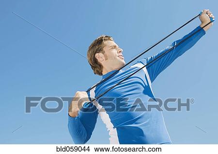 Hispanic man stretching with exercise band View Large Photo Image Picture - Hispanic man stretching with exercise band. Fotosearch