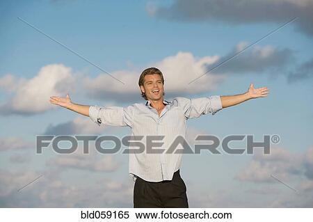 Stock Photography - Hispanic man with arms outstretched. Fotosearch