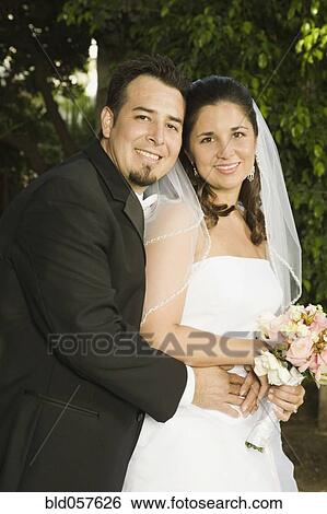 Hispanic newlyweds hugging View Large Photo Image Stock Photograph - Hispanic newlyweds hugging. Fotosearch
