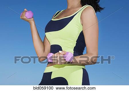 Hispanic woman exercising with dumbbells View Large Photo Image Stock Image - Hispanic woman exercising with dumbbells. Fotosearch