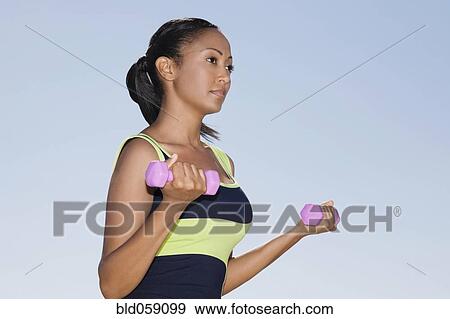Hispanic woman exercising with dumbbells View Large Photo Image Stock Photo - Hispanic woman exercising with dumbbells. Fotosearch