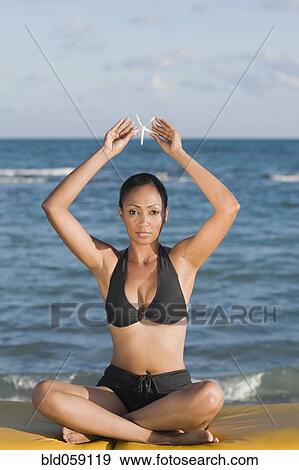 Hispanic woman holding starfish over head View Large Photo Image Stock Photo - Hispanic woman holding starfish over head. Fotosearch