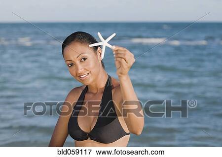 Hispanic woman holding starfish View Large Photo Image Stock Photo - Hispanic woman holding starfish. Fotosearch