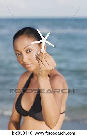 Hispanic woman holding starfish View Large Photo Image Stock Photograph - Hispanic woman holding starfish. Fotosearch