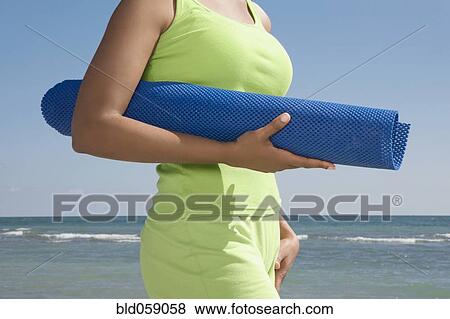 Hispanic woman holding yoga mat View Large Photo Image Stock Photo - Hispanic woman holding yoga mat. Fotosearch