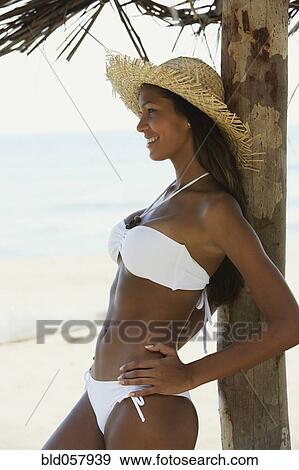 Hispanic woman in bikini leaning against tree View Large Photo Image Stock Photo - Hispanic woman in bikini leaning against tree. Fotosearch
