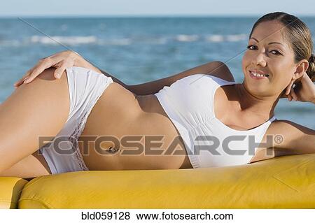 Hispanic woman laying in front of water View Large Photo Image Stock Photo - Hispanic woman laying in front of water. Fotosearch