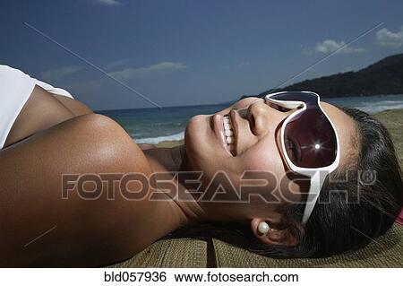 Hispanic woman laying on beach View Large Photo Image Stock Photograph - Hispanic woman laying on beach. Fotosearch