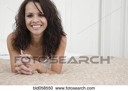 Hispanic woman laying on bed View Large Photo Image Stock Image - Hispanic woman laying on bed. Fotosearch