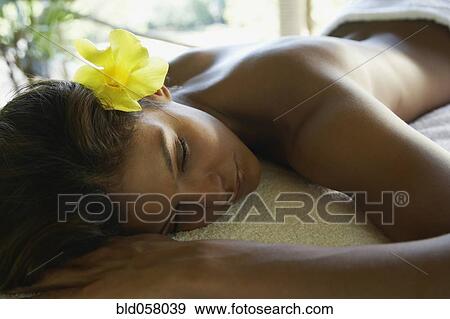 Stock Photo - Hispanic woman laying on spa table. Fotosearch