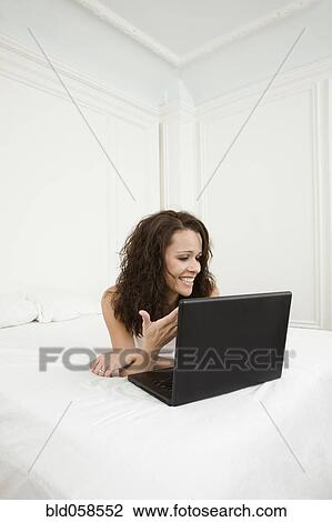 Stock Image - Hispanic woman looking at laptop. Fotosearch