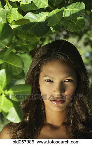 Hispanic woman next to plants View Large Photo Image Stock Photograph - Hispanic woman next to plants. Fotosearch