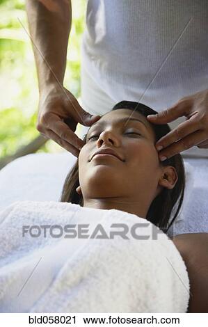 Stock Image - Hispanic woman receiving facial massage. Fotosearch