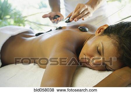 Hispanic woman receiving spa stone treatment View Large Photo Image Stock Photo - Hispanic woman receiving spa stone treatment. Fotosearch
