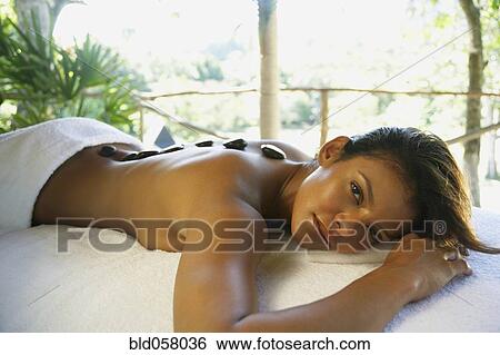 Hispanic woman receiving spa stone treatment View Large Photo Image Stock Photograph - Hispanic woman receiving spa stone treatment. Fotosearch