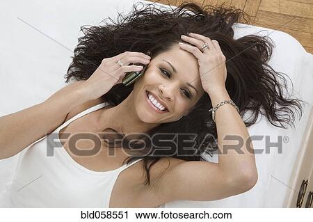 Stock Image - Hispanic woman talking on cell phone. Fotosearch