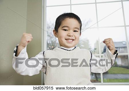 Mixed Race boy flexing muscles View Large Photo Image Stock Photography - Mixed Race boy flexing muscles. Fotosearch
