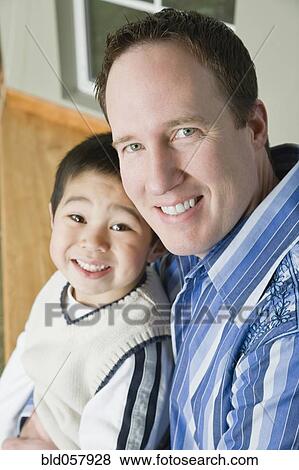 Mixed Race father and son hugging View Large Photo Image Stock Photo - Mixed Race father and son hugging. Fotosearch