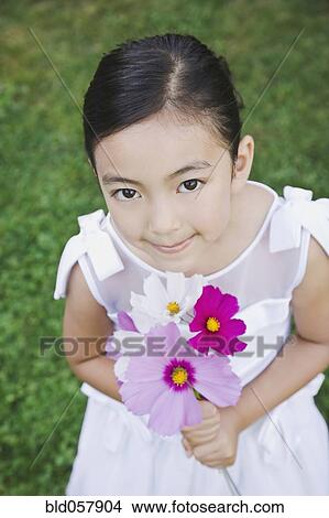 Mixed Race girl holding flowers View Large Photo Image Picture - Mixed Race girl holding flowers. Fotosearch