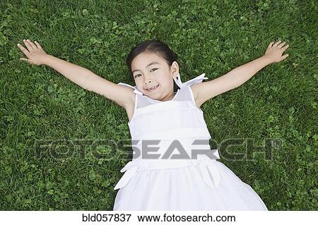 Stock Photo - Mixed Race girl laying in grass. Fotosearch