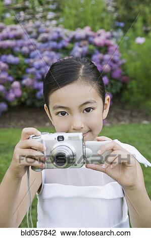 Stock Image - Mixed Race girl taking photograph. Fotosearch